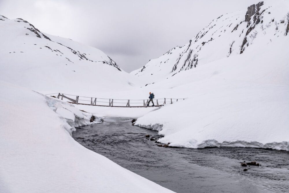 Randonneur solitaire traversant un pont dans les montagnes du sud de la Norvège